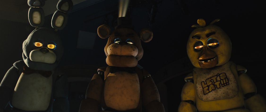 Three animatronics staring at the viewer in a still from the film 'Five Nights at Freddy's'