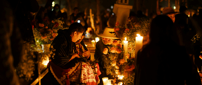 what-is-dia-de-los-muertos_feature Photo of people gathering in front of altar.