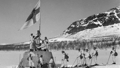 Raising the flag on the three country cairn between Norway, Sweden, and Finland