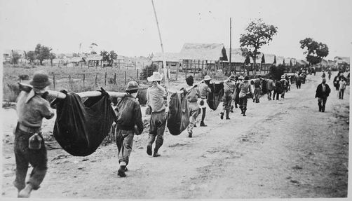 photo from the bataan death march of prisoners carrying comrades