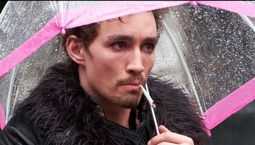 Klaus Hargreeves stands with a lit cigarette in his mouth in a still from 'The Umbrella Academy.'