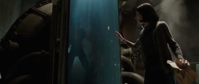 a woman approaches a fish tank with a human-like silhouette inside