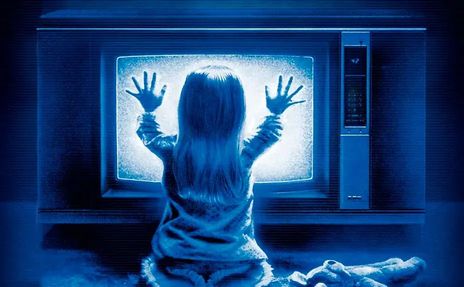 poltergeist-movie little girl with her hands on a bright blue glowing tv