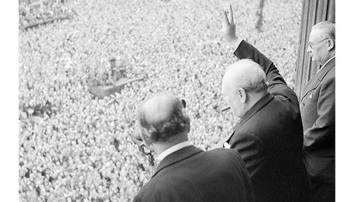 Winston Churchill gives the sign of victory to crowds in Whitehall, London