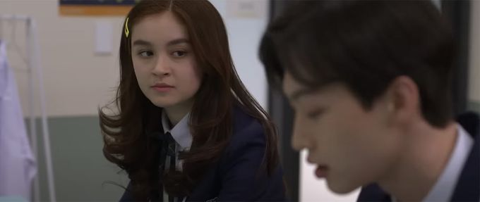 a girl looks at a boy in the screenshot of xo, kitty season 1