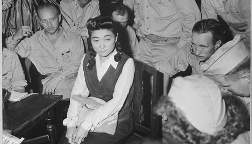 iva toguri d'aquino photo of D'Aquino seated on a chair surrounded by members of the press