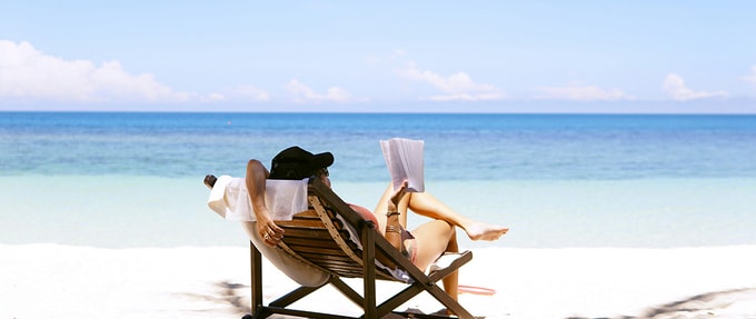 a woman reads on the beach