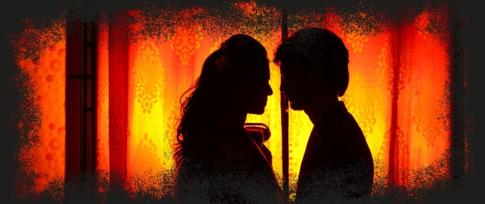 Romantic couple silhouetted against an orange background 