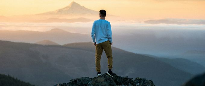 Man looking out into a mountain sunset. 