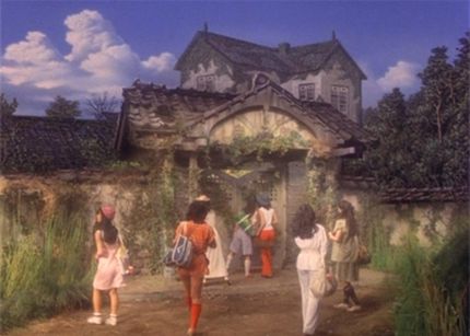 A group of people approaching a house, in a still from the film 'Hausu.'