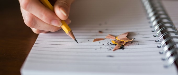 the-10-best-pieces-of-writing-advice-from-my-mfa Hand with pencil writing on notebook paper with pencil shavings