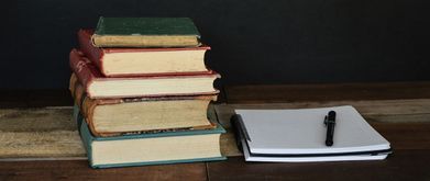 five books next to a notebook