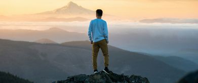 Man looking out into a mountain sunset. 