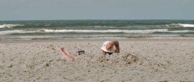 person reading an ebook on the beach